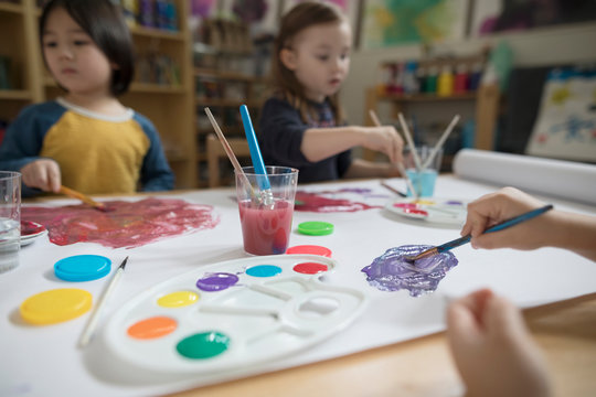 Preschool boy and girl painting in art classroom