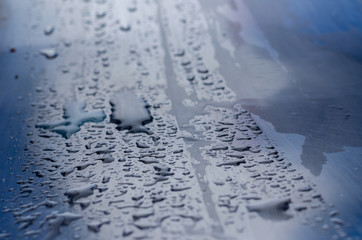 Closeup of raindrops and spray of rain on a metal table. Pure metal raindrops.  Eye level shooting....