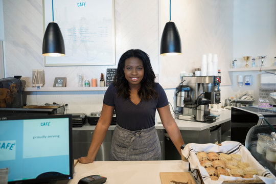 Portrait confident female small business owner working behind bakery counter