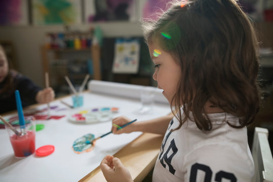 Preschool girl painting in art class