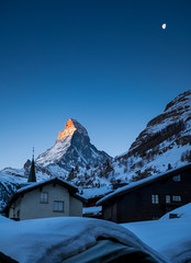 sunrise on Matterhorn with Alpenglow and moon in winter