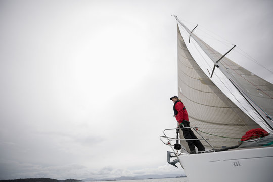 Woman standing at bow of sailboat