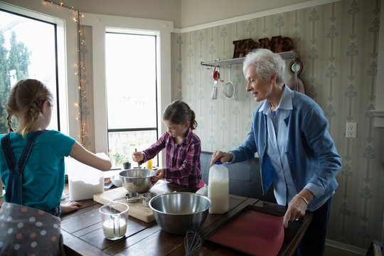 Grandmother And Granddaughters Baking In Kitchen