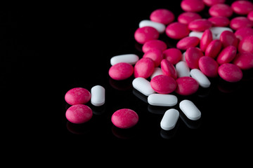 Obraz na płótnie Canvas Pills tablets vitamins capsules drugs black background close up macro shot
