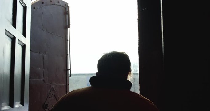 Silhouette of old hetman come out from a building