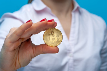 Young unidentified woman holding a bitcoin coin
