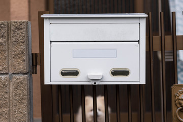 White mailbox or post box at a gate of a residential house. 