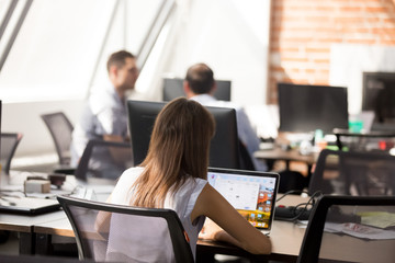 Female employee working on laptop in coworking space