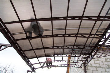 A worker mounts a metal canopy in the courtyard of the house