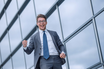 happy business man standing near office building.