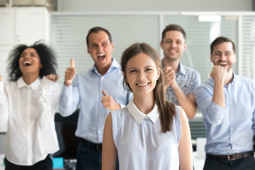 Portrait of excited employees posing with female team leader