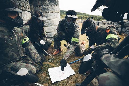 Paintballing team with map planning strategy