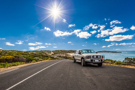 Vehicle driving along scenic ocean drive under beautiful sky and shining sun in South Australia