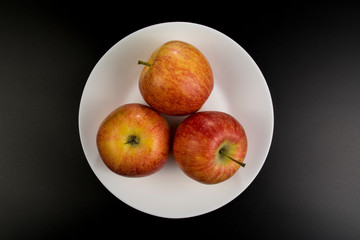 Three apples lie on a plate