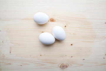 Three egs on a wooden background.