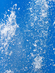 Splashing water from a fountain on a background of blue sky