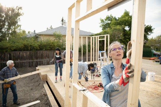 Female Volunteer Lifting Frame, Helping Build House