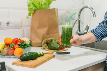 Benefits Of Cucumber juice. Green smoothies cooking for detox and weight loss. Glass of fresh cucumber juice on home kitchen table.