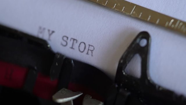 Typing words “my story” on a vintage typewriter. Close up, selective focus.