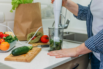 Benefits Of Cucumber juice. Green smoothies cooking for detox and weight loss. Glass of fresh cucumber juice on home kitchen table.