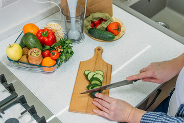 Benefits Of Cucumber juice. Green smoothies cooking for detox and weight loss. Glass of fresh cucumber juice on home kitchen table.