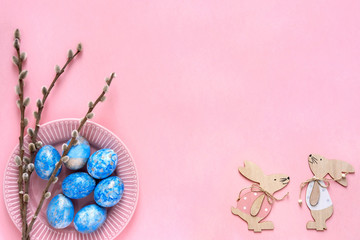 Naklejka premium Easter greeting card with blue easter eggs and easter bunny on pink pastel background. Top view with space for your text.