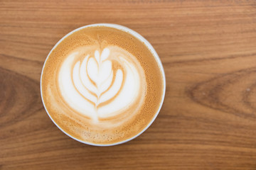 Coffee cup with Latte art on wooden table menu in coffee break time.Latte art froth design pattern...