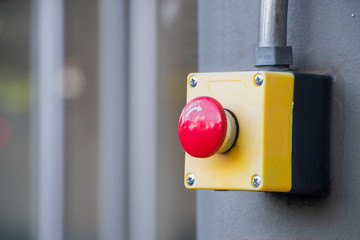 Red Reset button on the wall. red emergency stop switch button in a factory building.