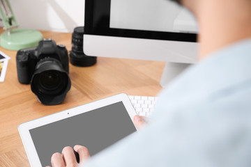 Professional photographer working at table in office, focus on hands