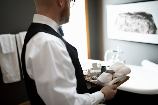 Male room service hotel staff preparing luxury bathroom