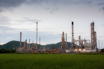 Fototapeta na wymiar Oil refinery located in the green meadow