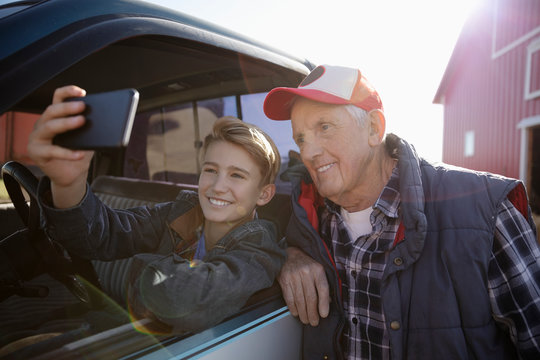 Farmer And Grandson Taking Selfie At Truck