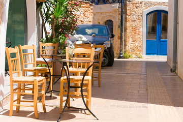 Tables and chairs  of a cafe in the greek street