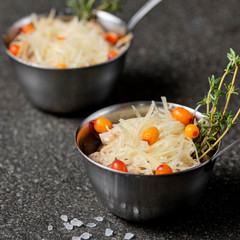Festive french julienne with sea buckthorn in a bowl on black stone background. Rustic style. Close up, selective focus.