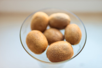 whole fruits kiwi in round glass, top view