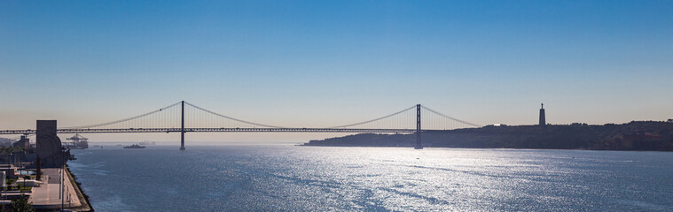 Panoramic view of the 25 de abril bridge over the Tagus River in Belem, Lisbon on a summer day