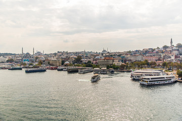 Naklejka premium Tourist ship sails on the Golden Horn, Istanbul, Turkey. Scenic sunny panorama of Istanbul city in summer. Beautiful waterfront of Istanbul at sunset. Concept of traveling and vacation in Istanbul.