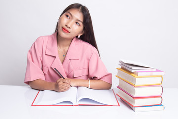 Young Asian woman read a book with books on table.