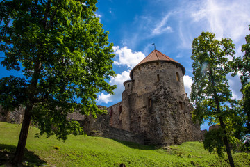 Fototapeta premium Medieval architecture. Castle in Europe. Summer Cesis, Latvia. Green trees. Sunny day. Under view.