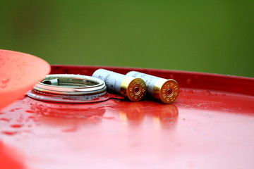 Shotgun cartridges on a red petroleum barrel