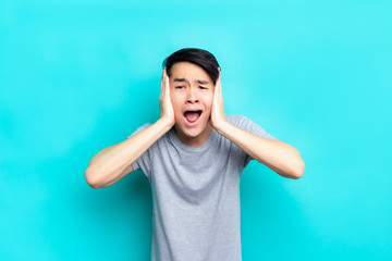 Headache asian man  isolated over blue background