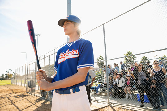 Focused, determined baseball player in batting box on sunny field