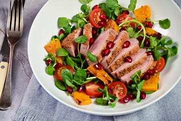 Duck breast fillets steak salad with roasted pumpkin, tomatoes and pomegranate seeds