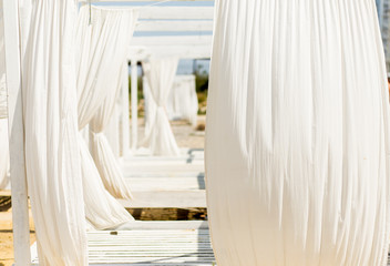Lounger bed with white curtins on the beach for a relaxing getaway.