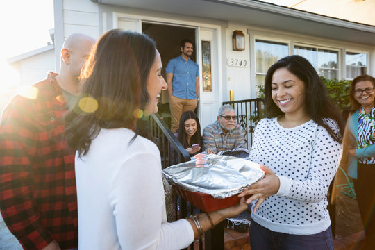 Latinx Woman Delivering Casserole To Neighbor