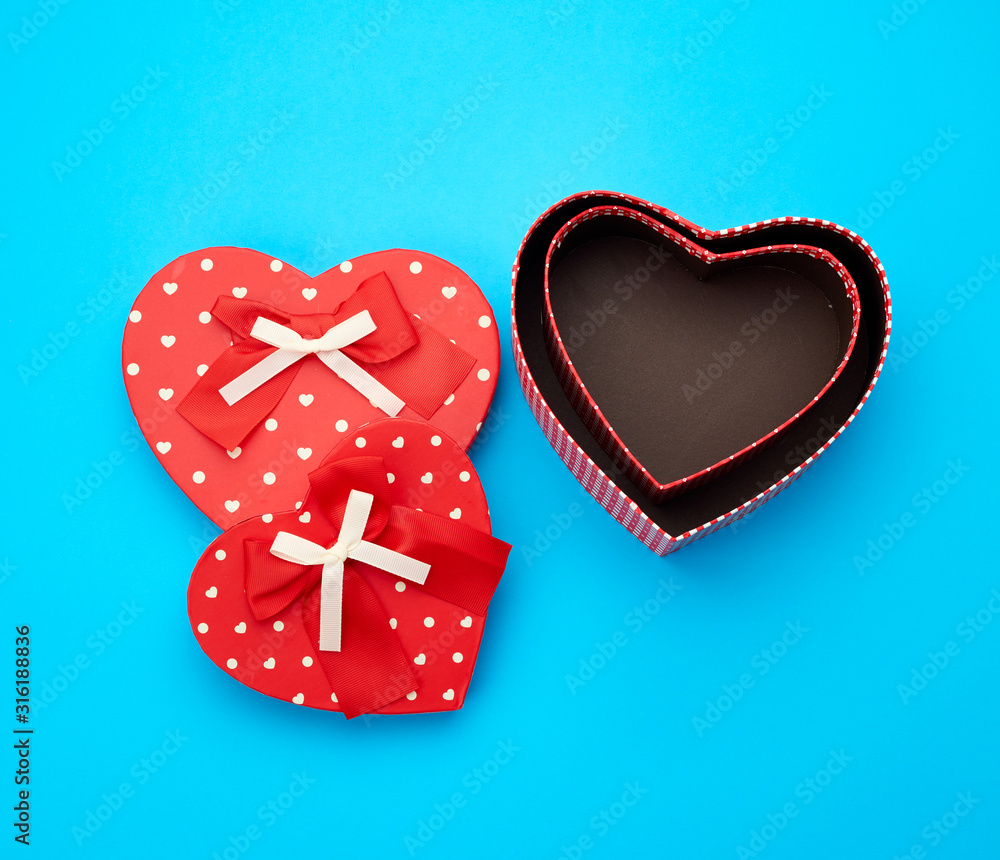 Poster open empty red cardboard box in the form of a heart on a light blue background