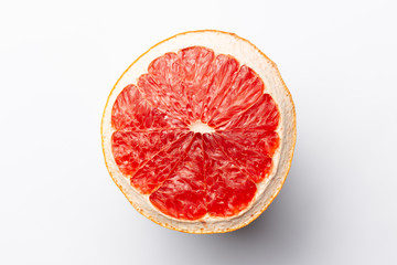 Slice of red dry grapefruit on gray background with shadow