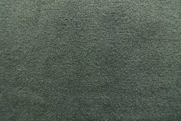 Fototapeta na wymiar Texture of dark green jersey fabric from above