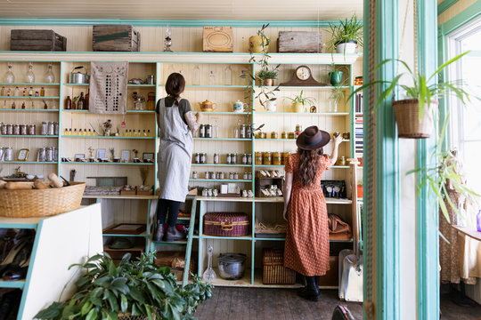 Female Business Owners Arranging Display In Apothecary Shop