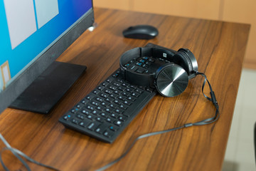 Obraz na płótnie Canvas keyboard and headphones on wooden table